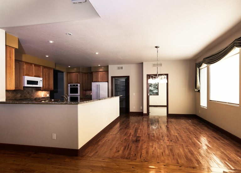a kitchen with a wooden floor and a large window
