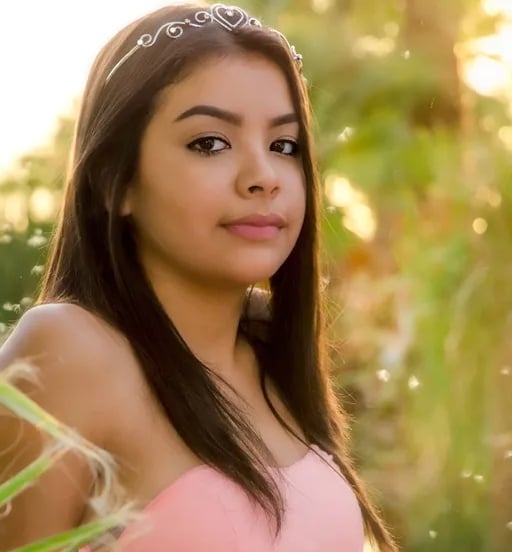 Joven con vestido rosa y tiara en sesión fotográfica al atardecer como parte de celebración de XV años.
