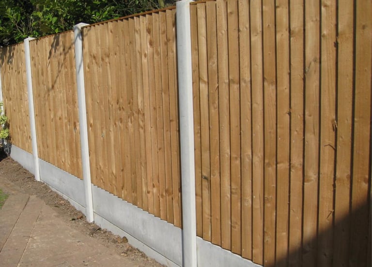 A long boundary fence, concrete posts and gravel boards fitted with Pillar to Post fence panels