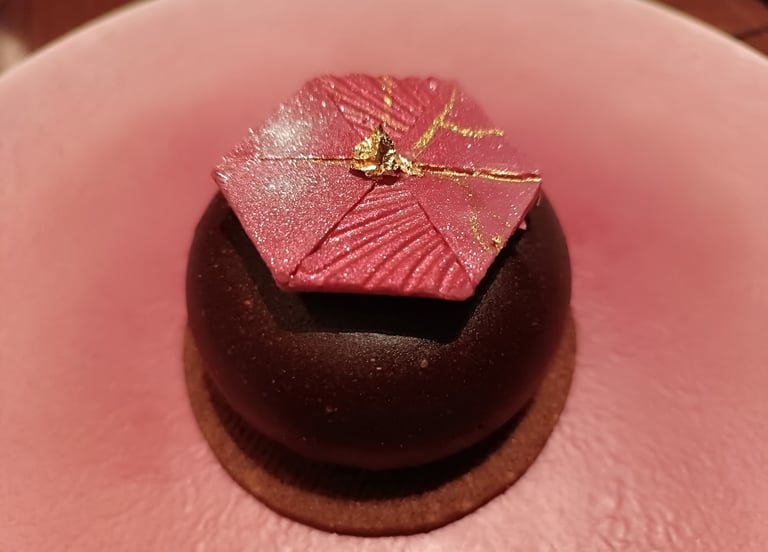 Dessert al cioccolato con decorazione geometrica rosa e foglia d'oro servito al ristorante Nobuya Milano