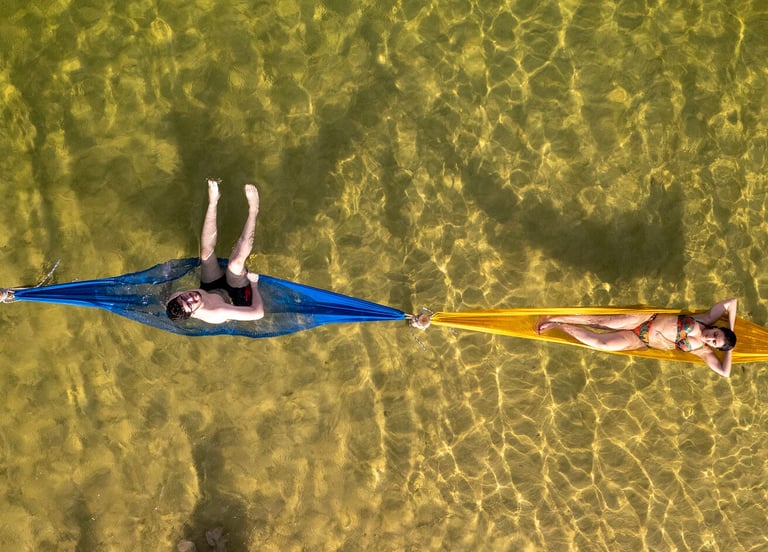 a man and woman laying on a hammock