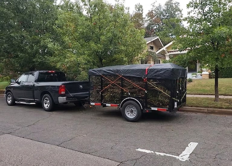 Professional truck and caged trailer hauling yard waste