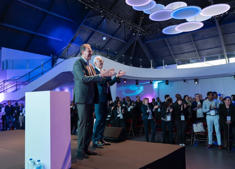Dirigeants d'entreprise sur une scène de plénière accueillant leurs partenaires.
