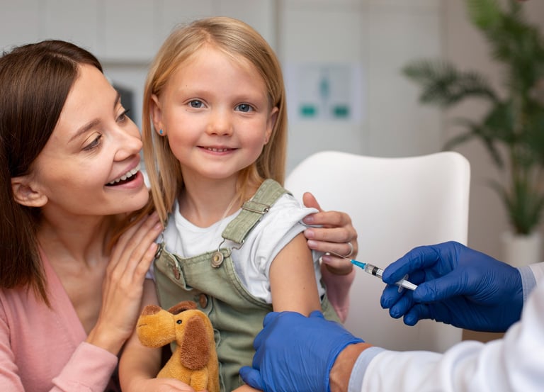 a girl sitting on her mother's lap receiving a vaccine from a healthcare professional