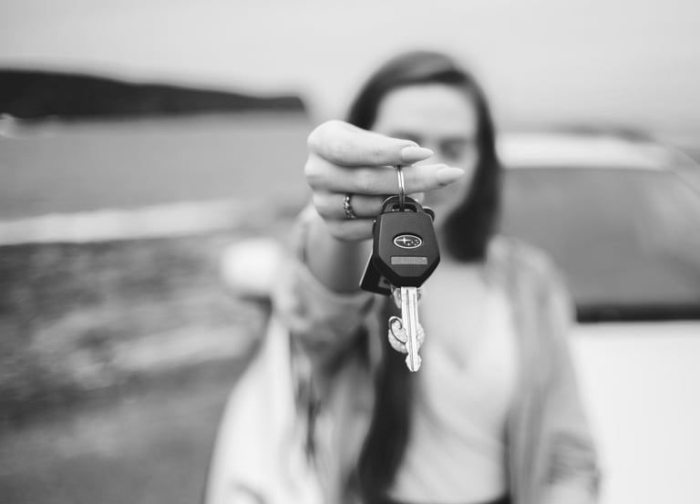 grayscale photo of a woman holding a keychain and a car keys