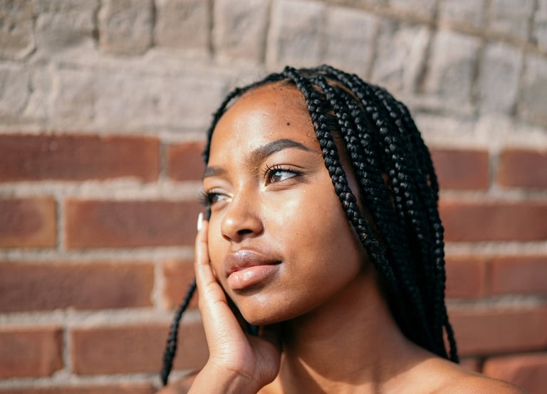 a black girl with black hair, caramel skin and a black dress