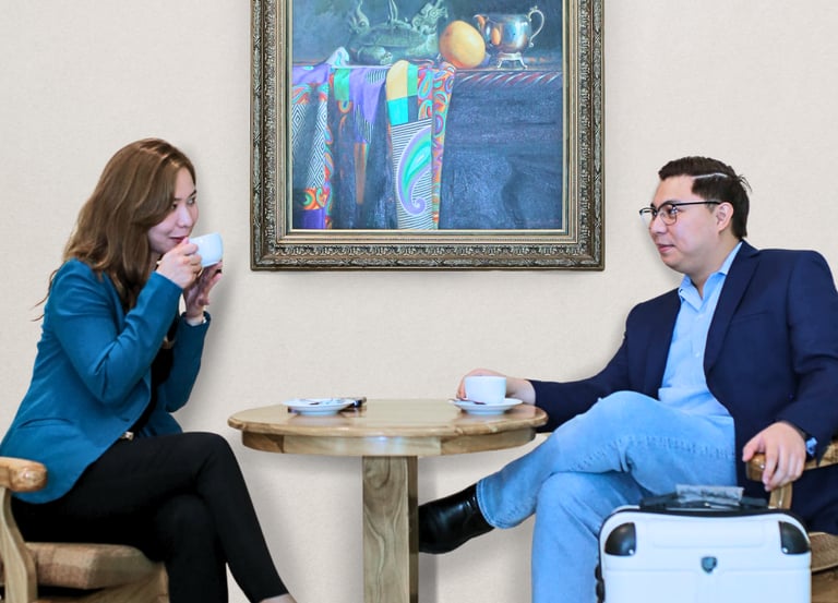 a businessman and woman sitting at a table with a suitcase