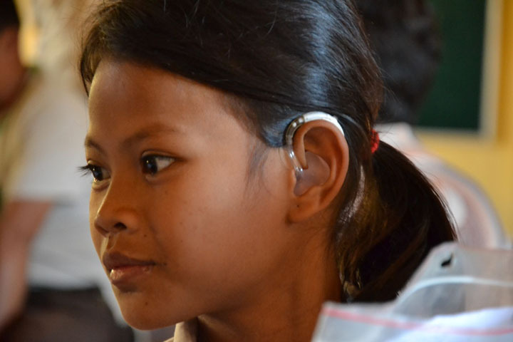 a young girl with hearing aid on her left ear