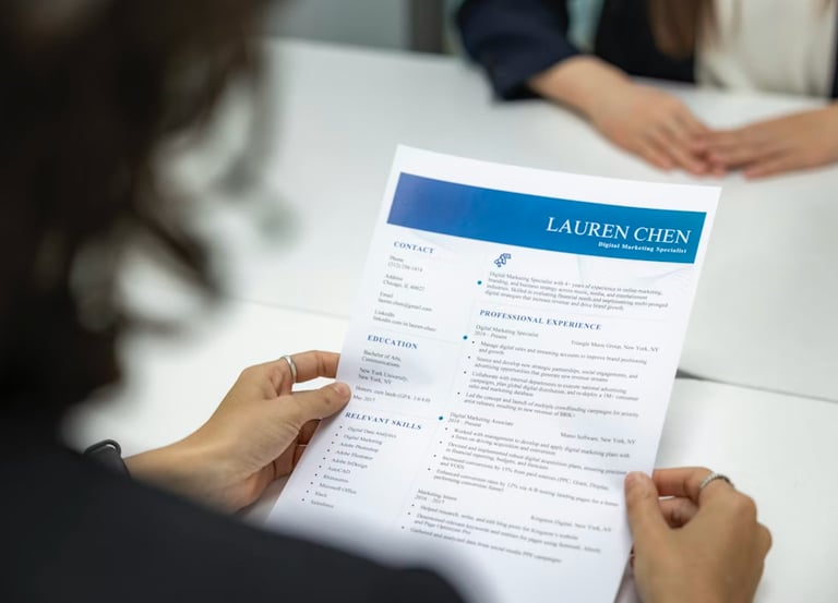A person holding a professional resume for a Digital Marketing Specialist during a job interview.
