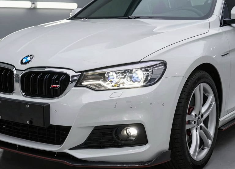A professional car detailer applying ceramic coating on a sleek black car under natural daylight.