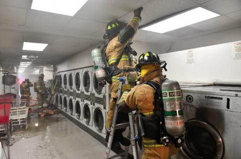 a firefighter is cleaning up after a clothes dryer fire