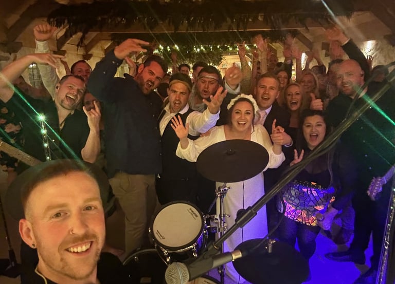 a group of people standing around a drum kit