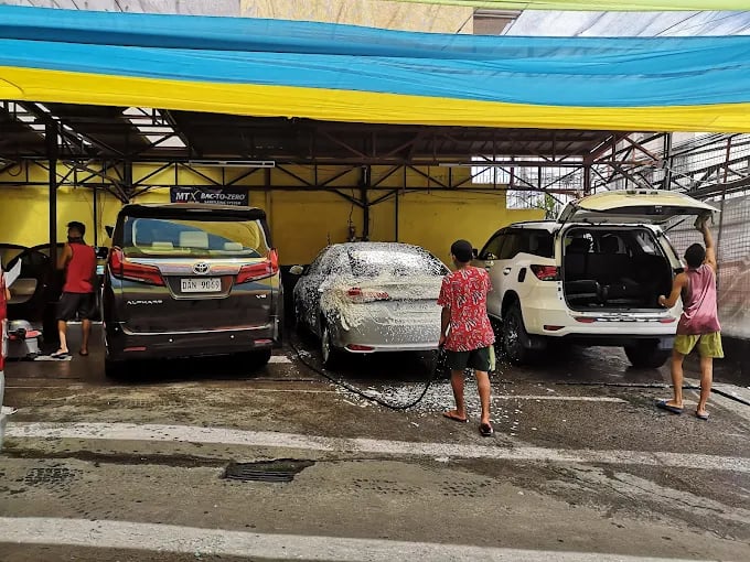 a man washing a car in a garage