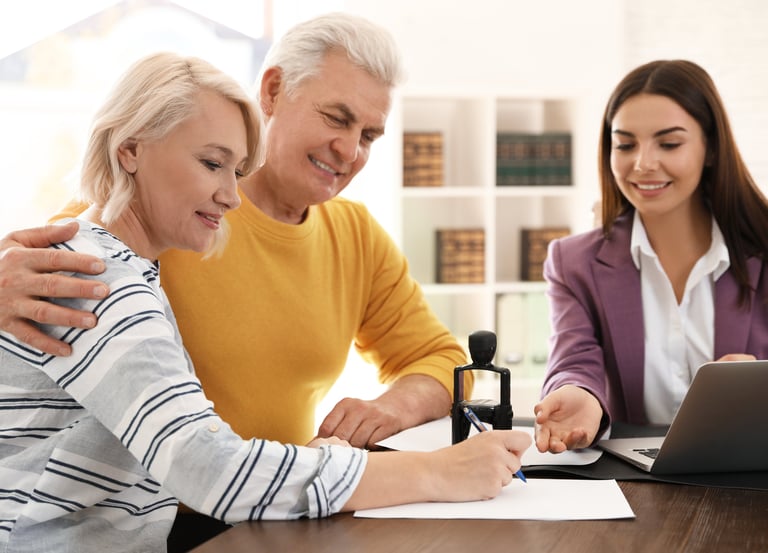 Professional mobile notary assisting couple with signing legal documents at their home.