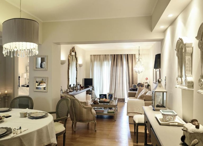 Elegant open plan living and dining room with classic furniture, crystal chandeliers, and neutral decor.