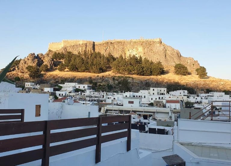 Panoramic view of the Acropolis of Lindos overlooking white houses in Rhodes, Greece.