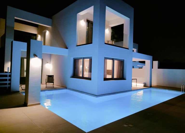 Modern luxury villa with a glowing swimming pool and minimalist architecture at night.