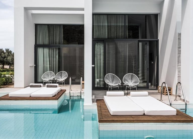 Luxury swim-up hotel rooms with private pool access, sun loungers, and modern terrace furniture.
