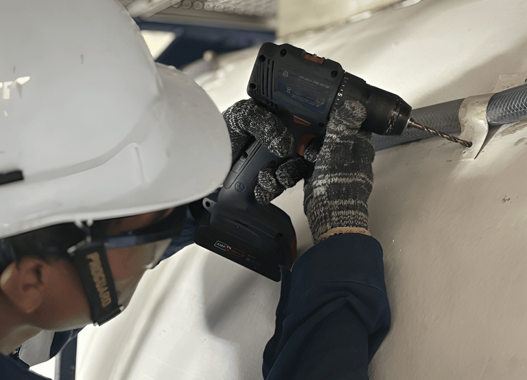 Technician installing external pipe lining on ISO tank during modification work