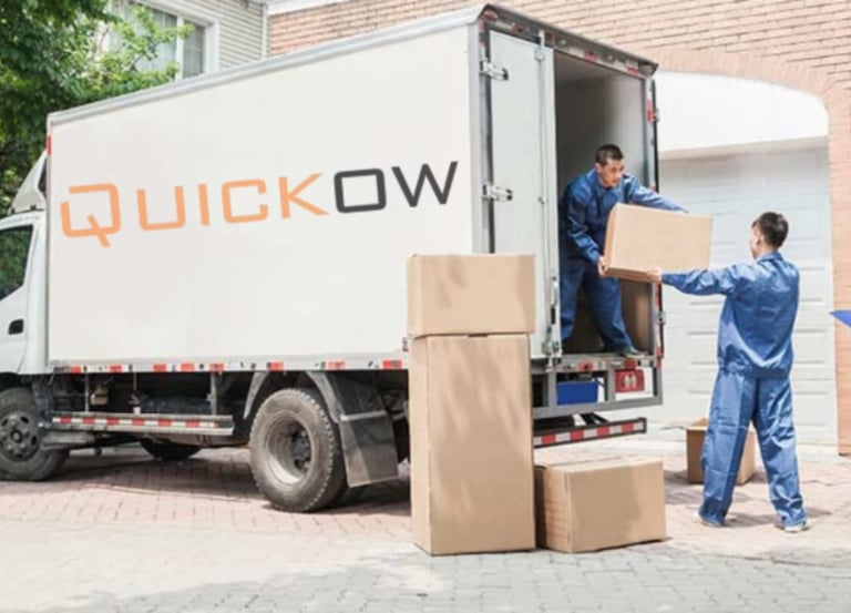 a group of people moving boxes into a moving truck