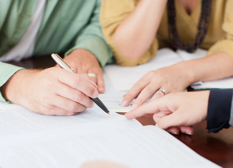 a couple signing a house purchase with a notary loan signing agent instructing where to sign
