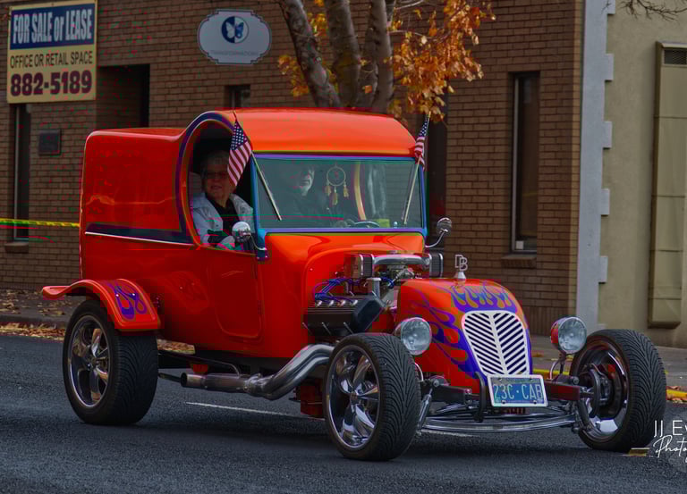 a orange hot rodder car with a man and a woman