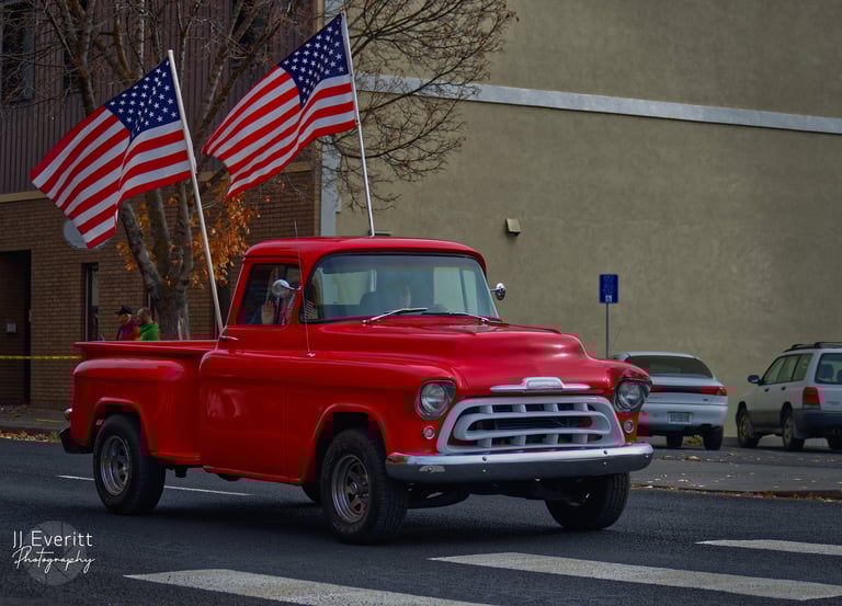 a red truck with two americans flags on it