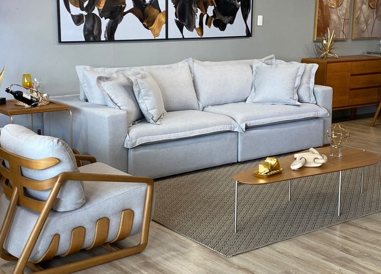 Sala de TV ou sala de estar com mesa de centro, tapete, quadros, estofado, poltrona e decoração