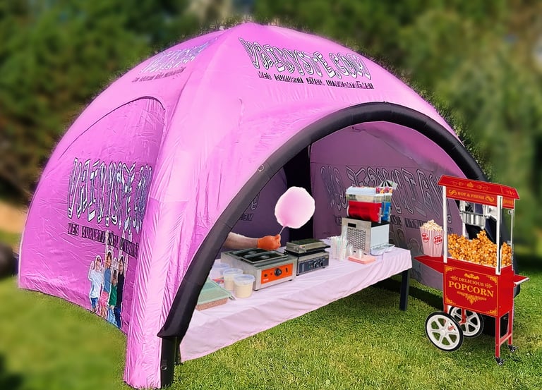 Pink inflatable event tent with cotton candy and popcorn machine rental for outdoor parties.