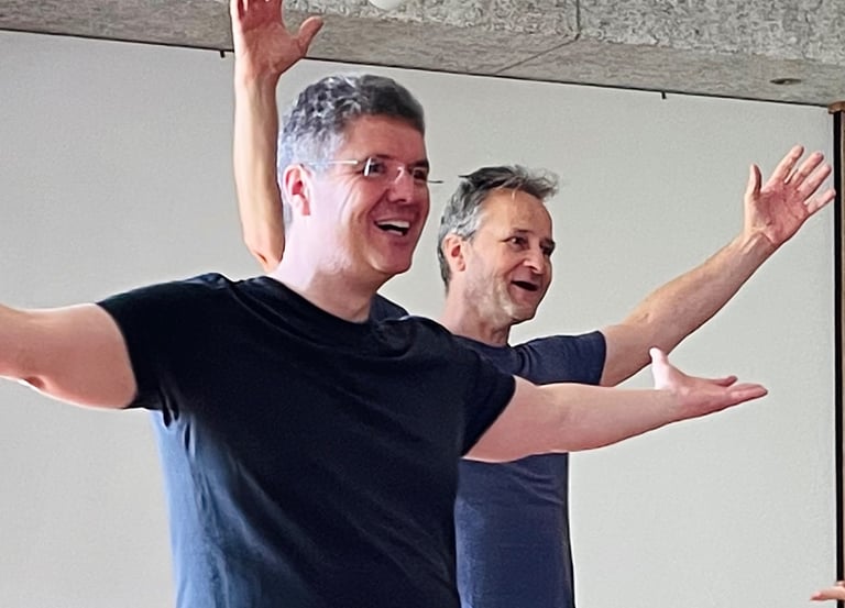 zwei strahlende Männer, die mit geöffneten Armen singen