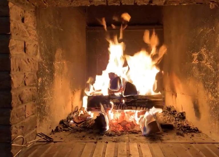ein Holzfeuer lodert im offenen Kamin
