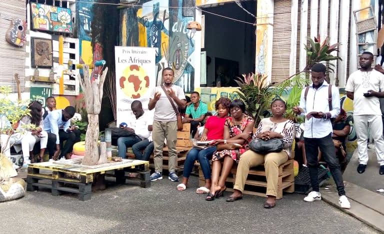 a group of people sitting on a bench in front of a building