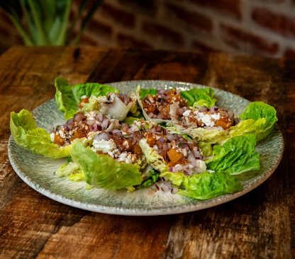 Ensalada fresca preparada con ingredientes de temporada, presentada en restaurante con cocina casera