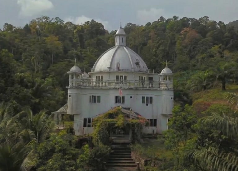 Majestic white domed palace surrounded by a lush tropical rainforest landscape.