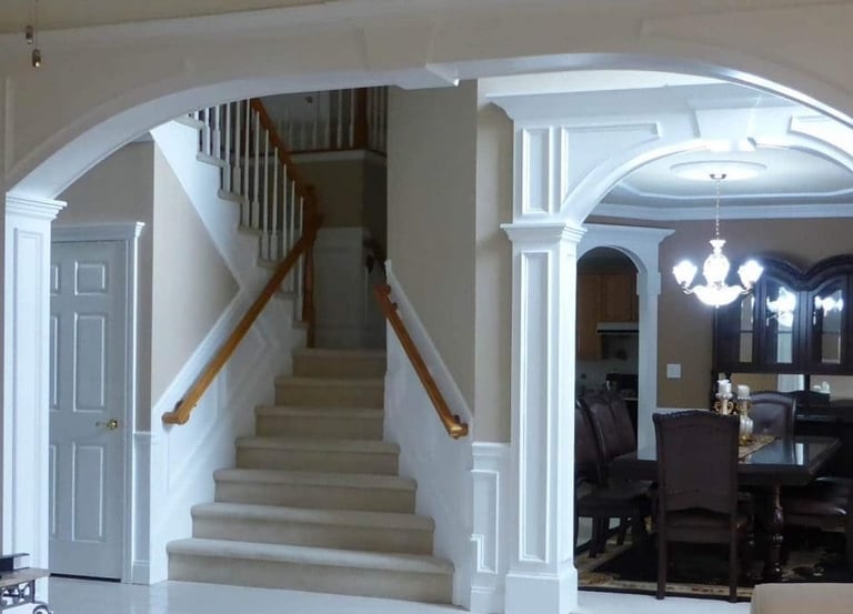 Interior arch and columns framing a staircase and dining room
