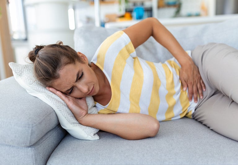 Mujer jovén recostado por dolor menstrual