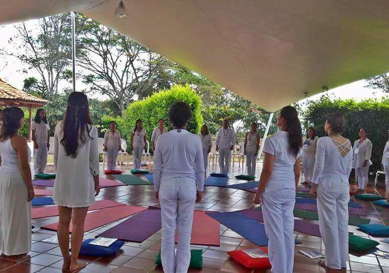 grupo de personas en circulo, vestidas de blanco