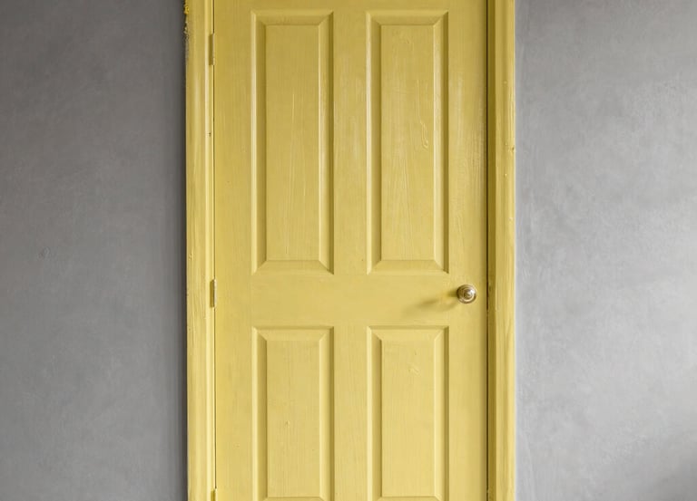 Professional painter applying white paint on apartment wall with protective floor covering in Porto Alegre.