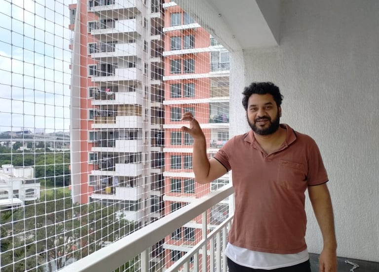 A technician carefully installing a sturdy safety net on a Pali Hill balcony.