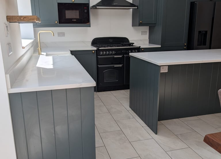 white counter top kitchen with a dark green/light grey wood cupboards