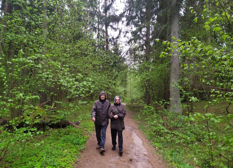 A man and woman walking down a path in the woods