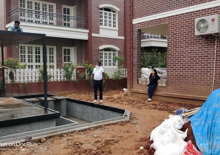 Close-up of concrete foundation base being poured or prepared for a heavy outdoor structure like a glass pergola or gazebo in