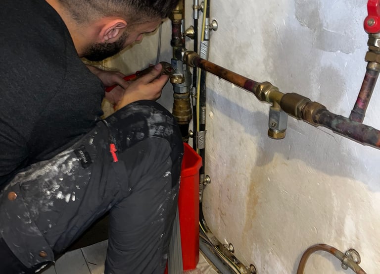 Une personne entrain de réparer une fuite d'eau