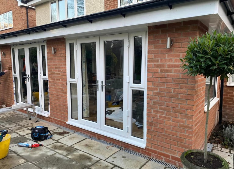 a house with a patio area, double french doors fitted into blockwork