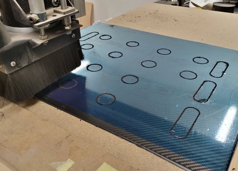 a machine is cutting through a piece of carbon fibre