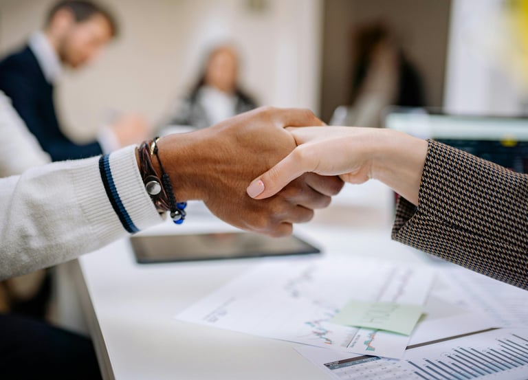 a man and woman shaking hands in a meeting room