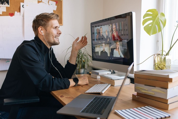 a man sitting at a desk with a laptop and a laptop