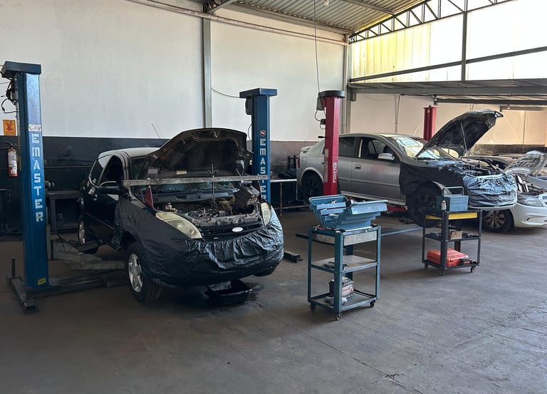 Imagem do pátio da oficina, mostrando elevadores e veículos em manutenção.