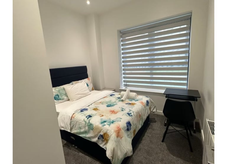 a neat bedroom with a bed and a desk