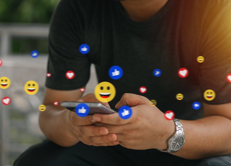 man typing on phone with emojis